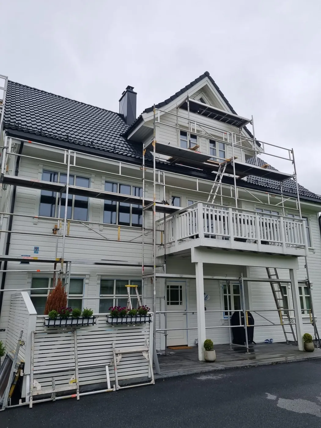 Stort bolighus med stillas under rehabilitering